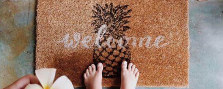 woman-standing-on-the-door-mat-with-a-welcome-writ-2022-08-01-04-52-06 (1)